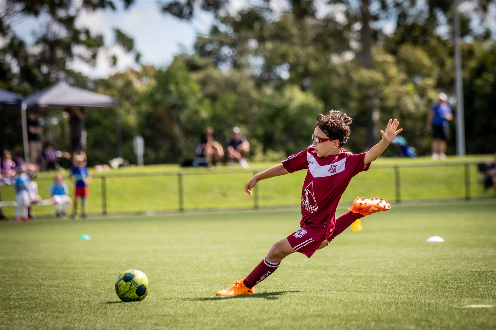 Vale player fully airborne on a diving strike, orange boots and sunglasses
